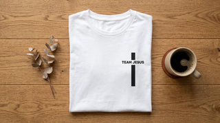 Team-Jesus-Shirt als Flatlay auf Eichenholz mit Kaffee