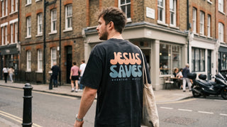 Junger Mann von hinten mit Jesus-Saves-Shirt mit Rückenprint auf der Straße