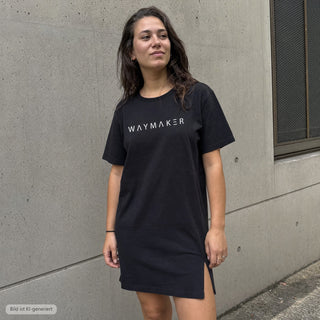 Waymaker T-Shirt Kleid schwarz, urbaner Look vor Betonwand (KI-generiertes Bild)