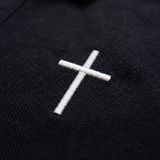 Nahaufnahme des gestickten Kreuzes auf der linken Brust des Kreuz Polo T-Shirts